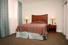 Comfortable bed with drapes and 2 lamps