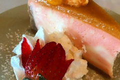 Slice of mango key lime pie with strawberry and cream